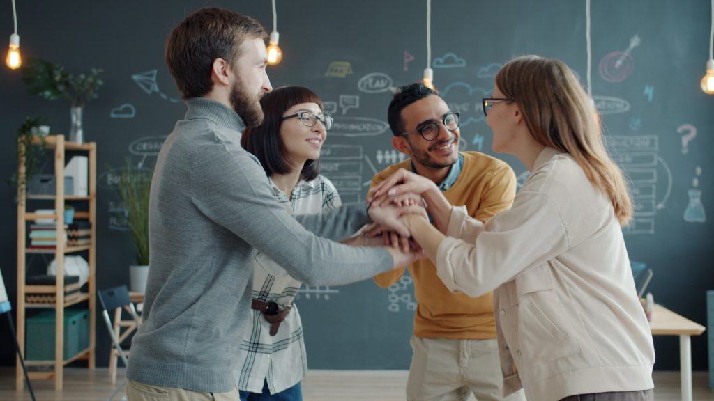 Diverse team celebrates success with a huddle.